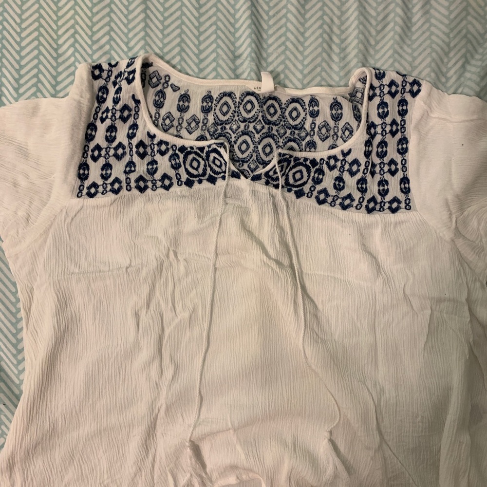 White blouse with blue pattern on collar